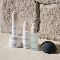 Bescher skincare products on a stone surface with a stone wall background